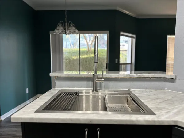 a kitchen view with a sink and large window