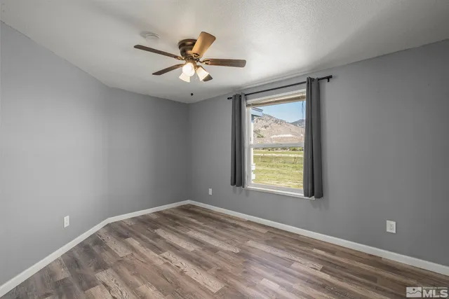 an empty room with a window and a fan