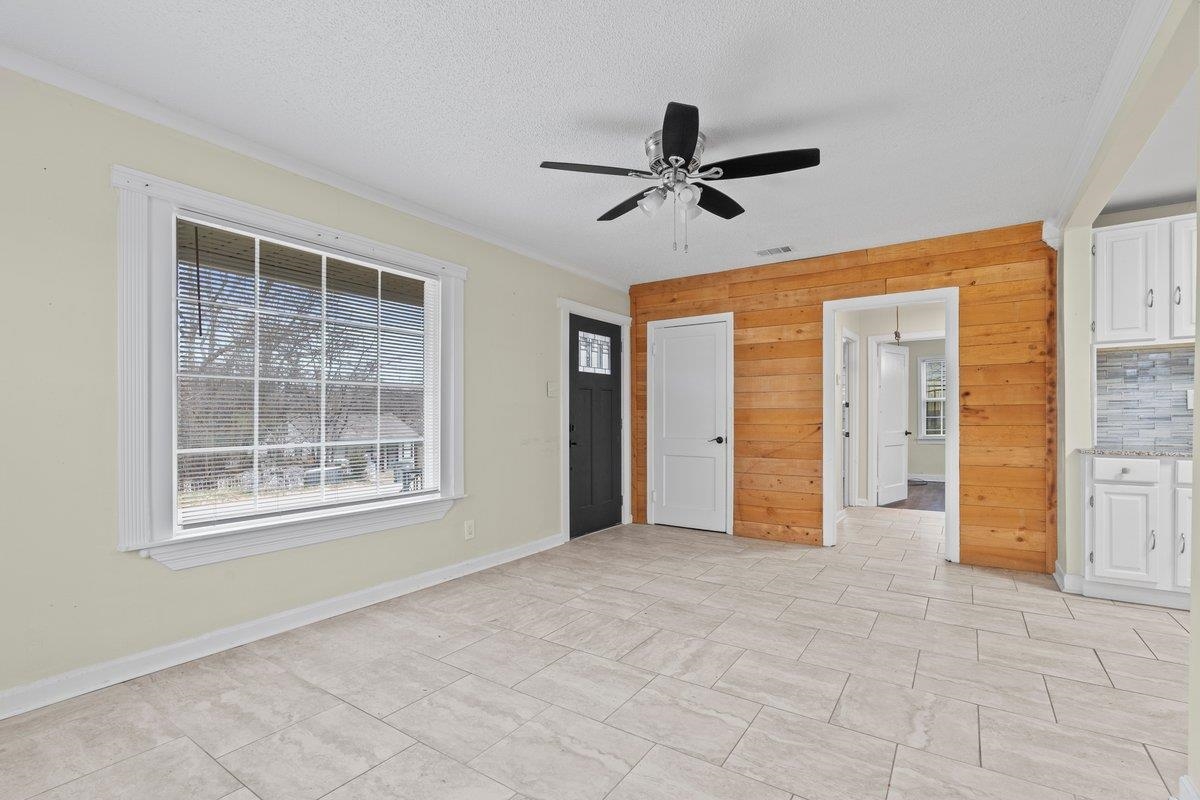 1012 Newell Road Memphis, TN 38111 - Photo 14 of 16 Interior space featuring ceiling fan, wooden walls, crown molding, and a textured ceiling