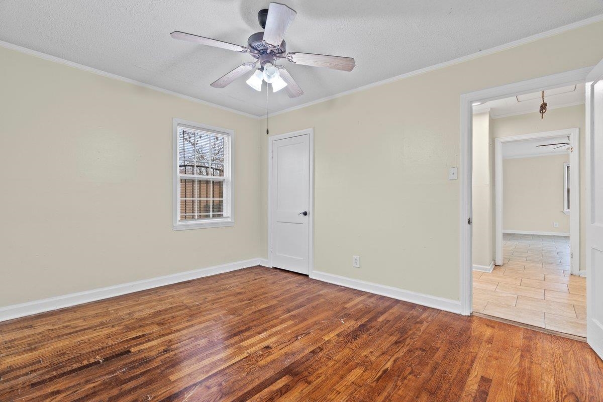 1012 Newell Road Memphis, TN 38111 - Photo 5 of 16 Empty room with a textured ceiling, ornamental molding, ceiling fan, and light wood-type flooring