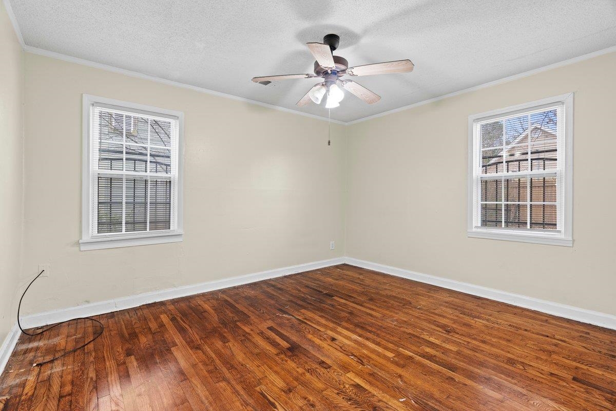 1012 Newell Road Memphis, TN 38111 - Photo 6 of 16 Unfurnished room with ceiling fan, ornamental molding, wood-type flooring, and a textured ceiling
