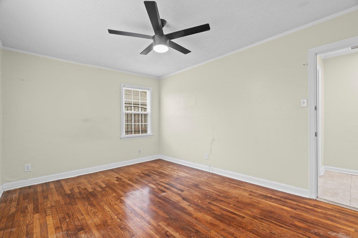 1012 Newell Road Memphis, TN 38111 - Photo 7 of 16 Empty room featuring ornamental molding, ceiling fan, a textured ceiling, and dark hardwood / wood-style flooring
