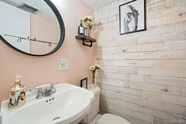a bathroom with a sink mirror and toilet