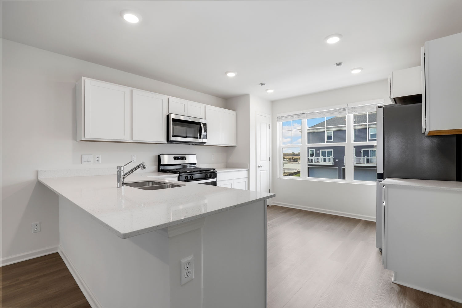 8746 Clover Lane St. John, IN 46373 - Photo 12 of 31 a kitchen with a sink a stove a microwave and a counter top space