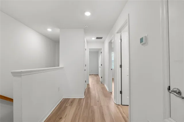 a view of a hallway with wooden floor