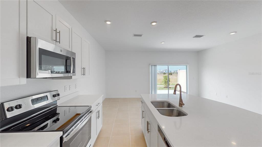 2415 Paravane Way Wesley Chapel, FL 33543 - Photo 3 of 23 a kitchen with a sink and a stove top oven