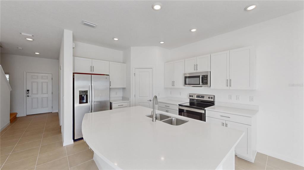 2415 Paravane Way Wesley Chapel, FL 33543 - Photo 6 of 23 a kitchen with stainless steel appliances a refrigerator sink and microwave