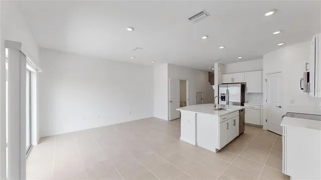 a large white kitchen with a stove top oven a sink and dishwasher