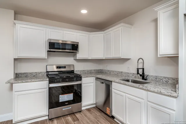 a kitchen with stainless steel appliances granite countertop a sink stove and microwave