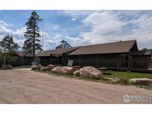 a couple of couches under an umbrella in front of house