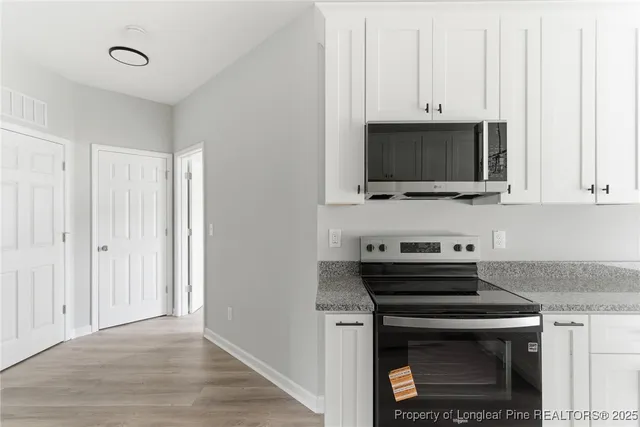 a kitchen with stainless steel appliances a stove a microwave and cabinets