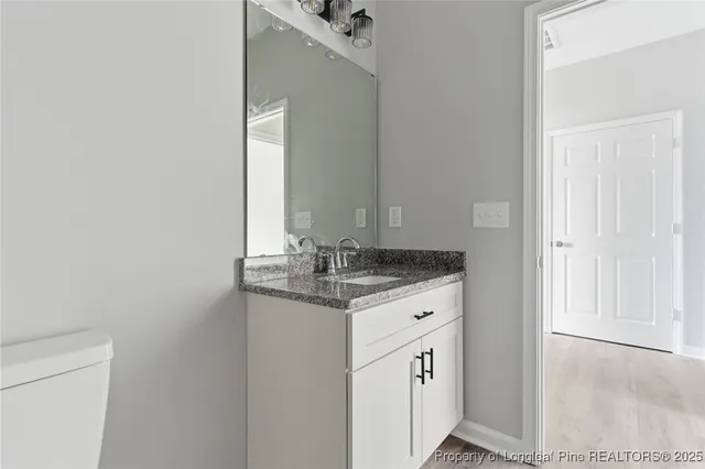 a bathroom with a granite countertop sink and a mirror