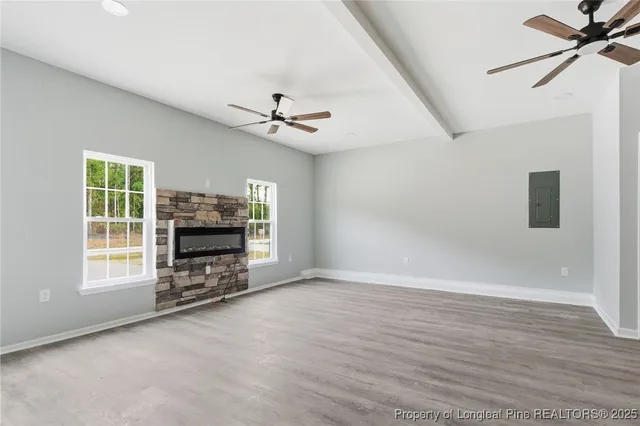 a view of an empty room with a fireplace and a window