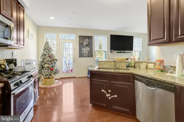 a kitchen with stainless steel appliances granite countertop a stove a microwave a sink and cabinets