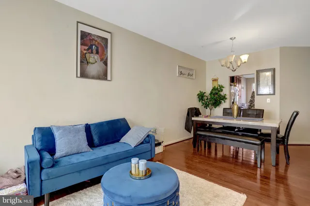 a living room with furniture a dining table and a potted plant