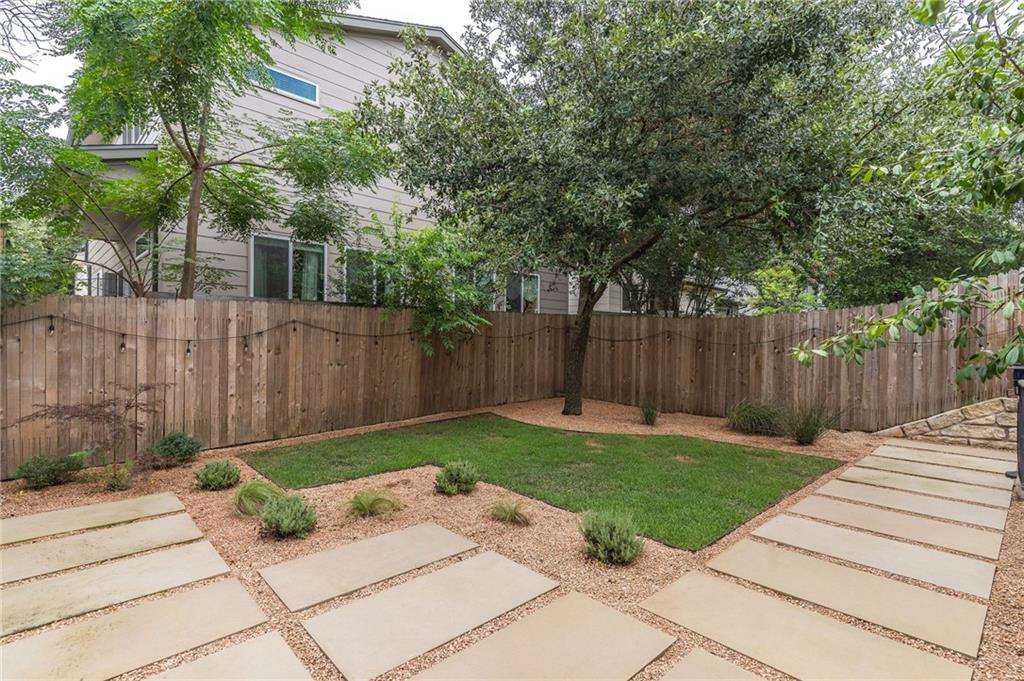 6708 Menchaca Road, Unit 14 Austin, TX 78745 - Photo 22 of 22 Private backyard featuring a manicured lawn, established tree, and wood privacy fencing