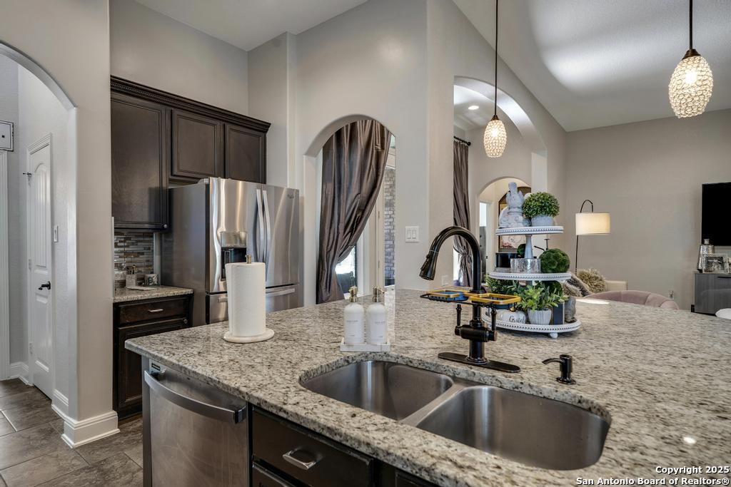 13326 Windmill Trace Helotes, TX 78023 - Photo 13 of 34 a kitchen with a sink a refrigerator and a sink
