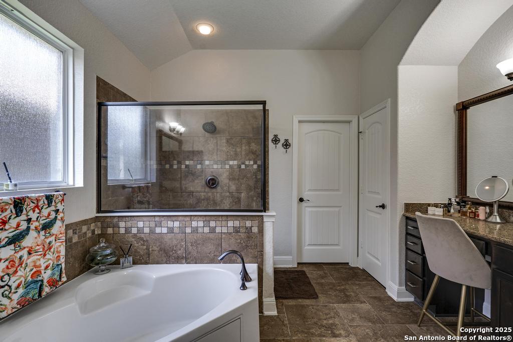 13326 Windmill Trace Helotes, TX 78023 - Photo 17 of 34 a bathroom with a bathtub and a shower
