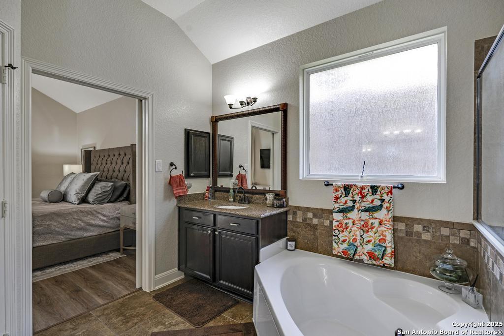 13326 Windmill Trace Helotes, TX 78023 - Photo 19 of 34 a bedroom with a bed and a dresser