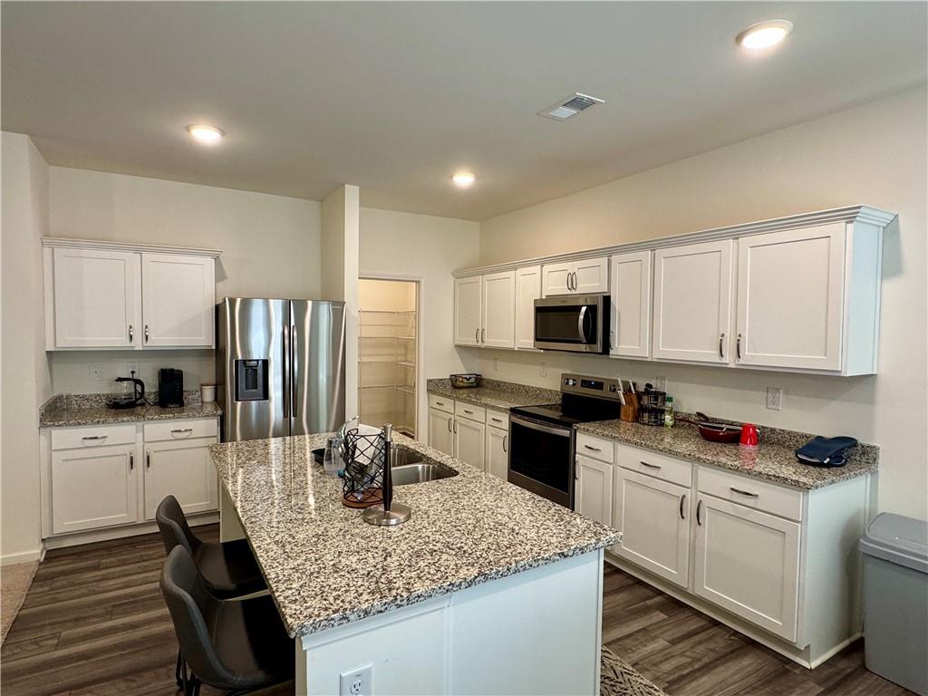 152 Andria Way Northwest Cartersville, GA 30120 - Photo 3 of 24 a kitchen with stainless steel appliances granite countertop a sink dishwasher stove refrigerator and cabinets with wooden floor