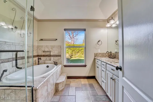 a bathroom with a tub sink and mirror