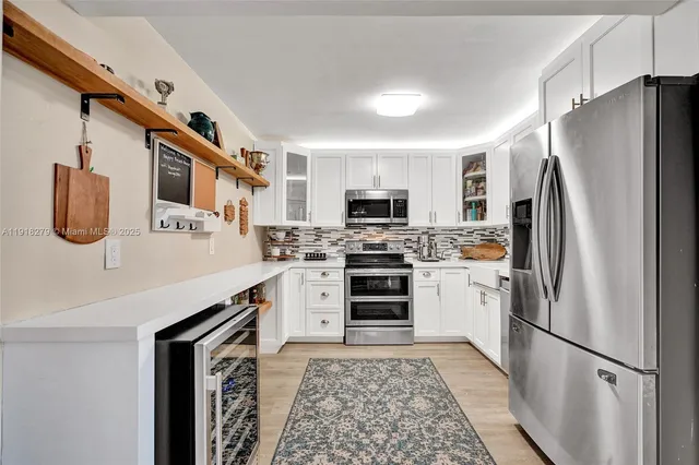 a kitchen with stainless steel appliances a refrigerator sink and stove