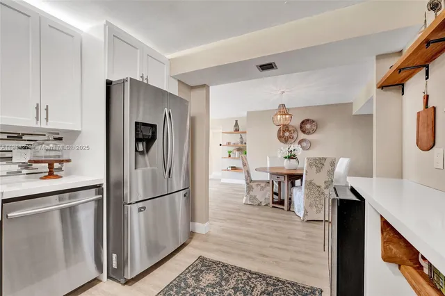 a kitchen with stainless steel appliances a refrigerator and a table