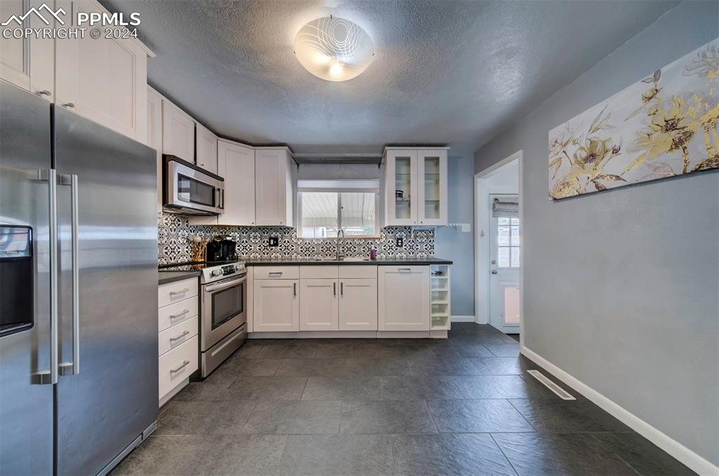 50 Duke Street Pueblo, CO 81005 - Photo 16 of 45 a kitchen with granite countertop white cabinets and stainless steel appliances