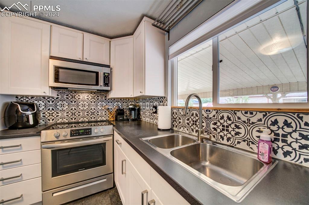 50 Duke Street Pueblo, CO 81005 - Photo 18 of 45 a kitchen with granite countertop a sink stove and microwave