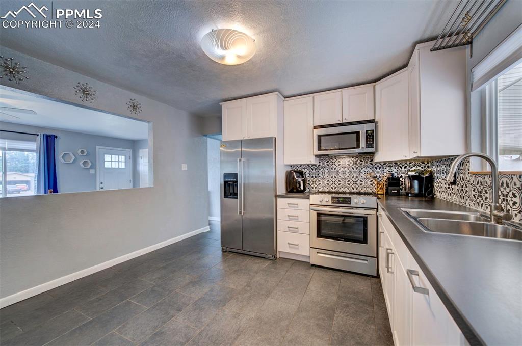 50 Duke Street Pueblo, CO 81005 - Photo 23 of 45 a kitchen with kitchen island granite countertop a stove top oven a sink and dishwasher