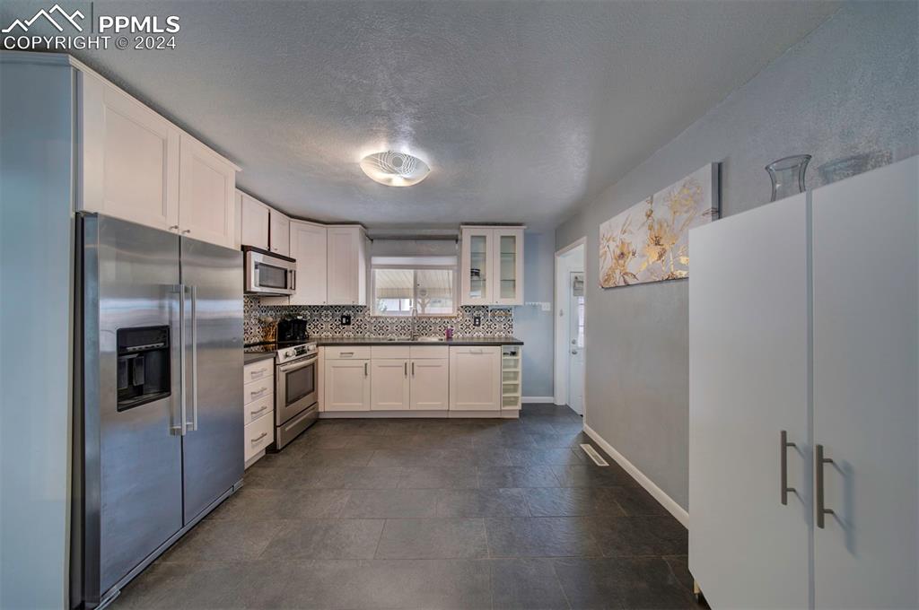 50 Duke Street Pueblo, CO 81005 - Photo 10 of 45 a large white kitchen with cabinets a sink and stainless steel appliances