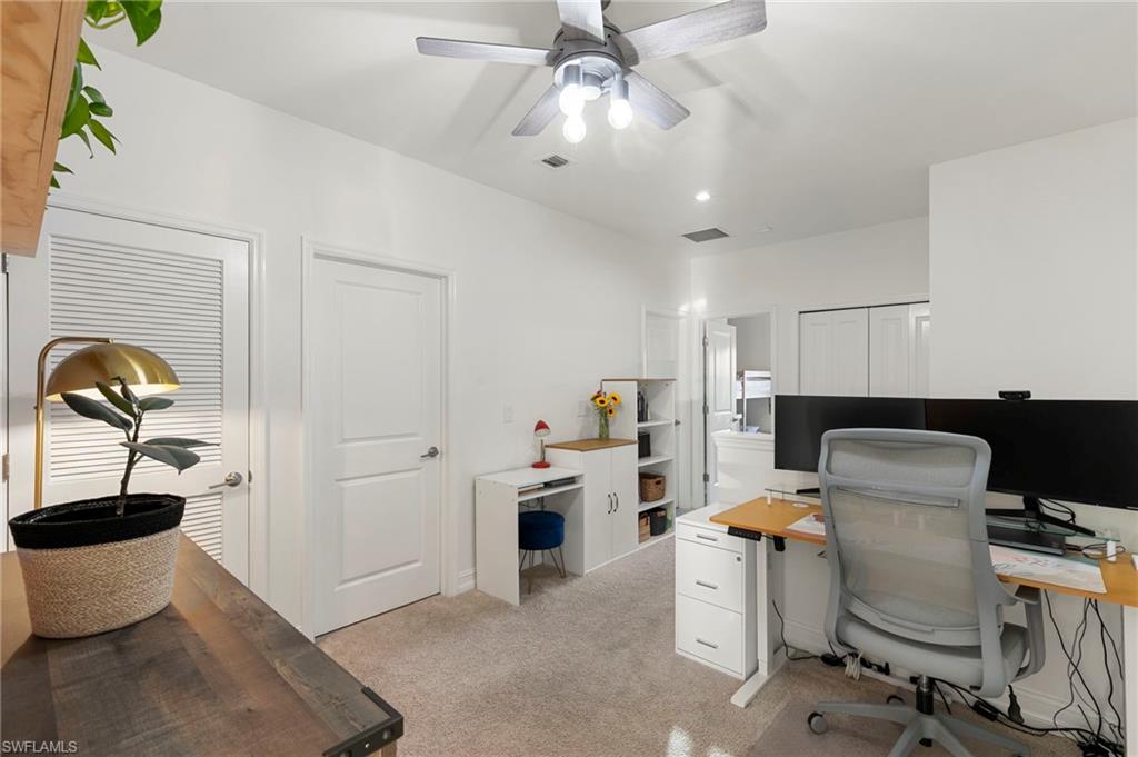 7421 Rockefeller Drive Naples, FL 34119 - Photo 12 of 37 a workspace with a desk chair and painted walls