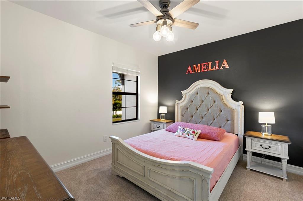 7421 Rockefeller Drive Naples, FL 34119 - Photo 21 of 37 a bedroom with a bed and a chandelier