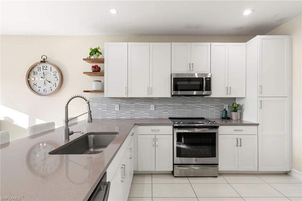 7421 Rockefeller Drive Naples, FL 34119 - Photo 8 of 37 a kitchen with a stove and a white refrigerator