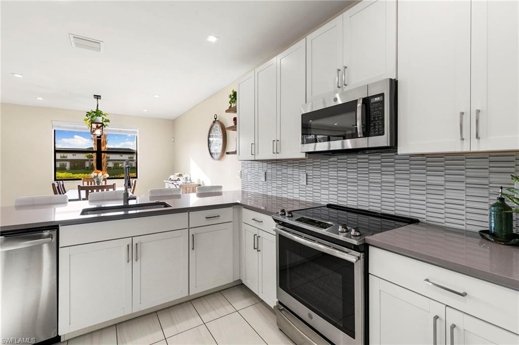 7421 Rockefeller Drive Naples, FL 34119 - Photo 10 of 37 a kitchen with cabinets stainless steel appliances and a sink