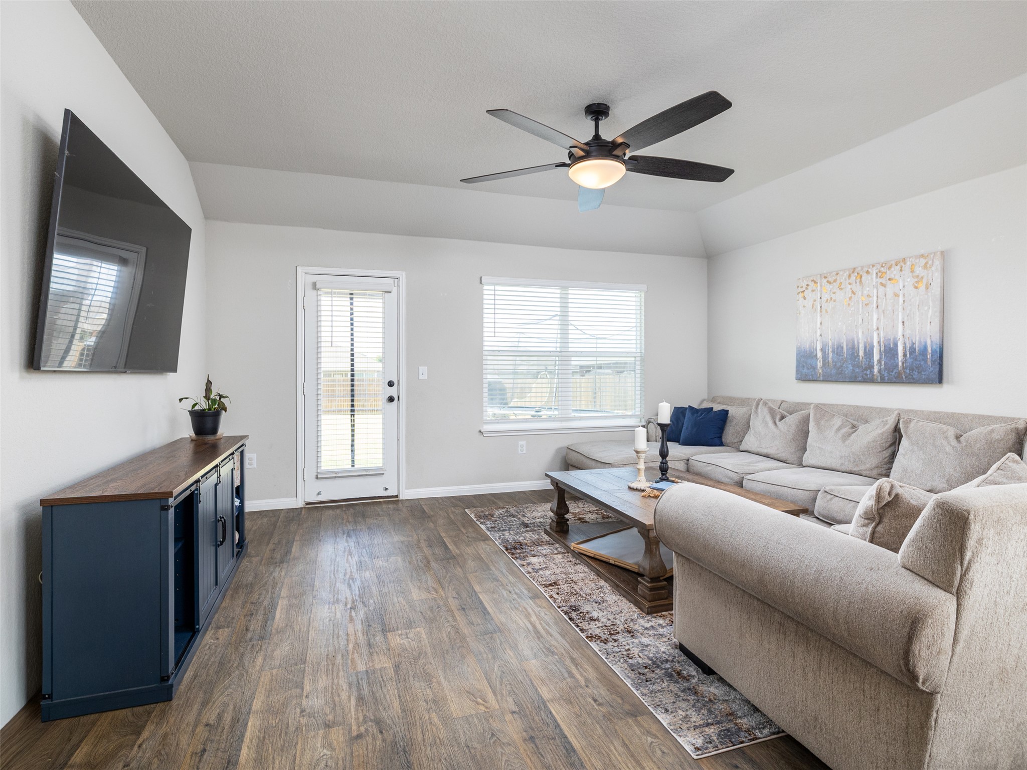 439 Hunter Loop Bertram, TX 78605 - Photo 5 of 23 A comfortable living area with high ceilings and wood flooring awaits gatherings.