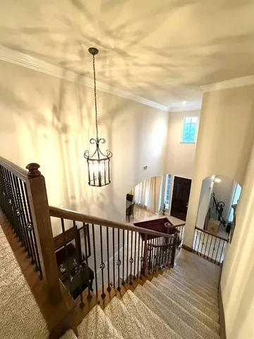 a view of a hallway to room with wooden floor and windows