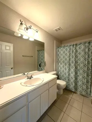 a spacious bedroom with a bed and a ceiling fan