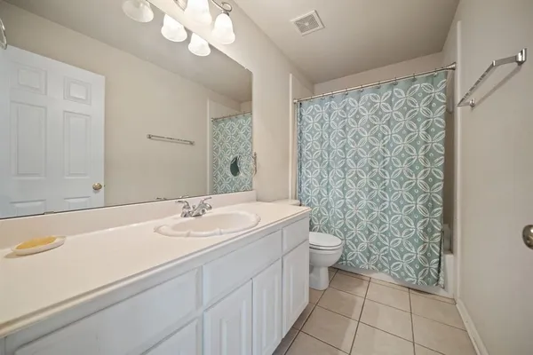 a bedroom with a bed and a chandelier fan