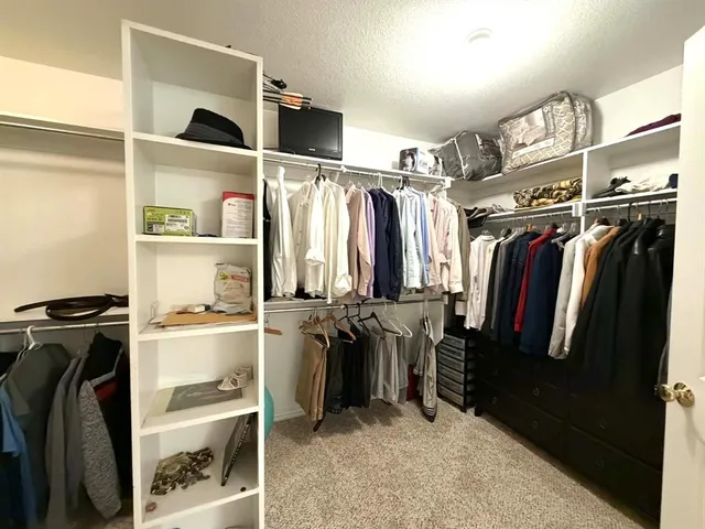 a large white kitchen with a large window and cabinets