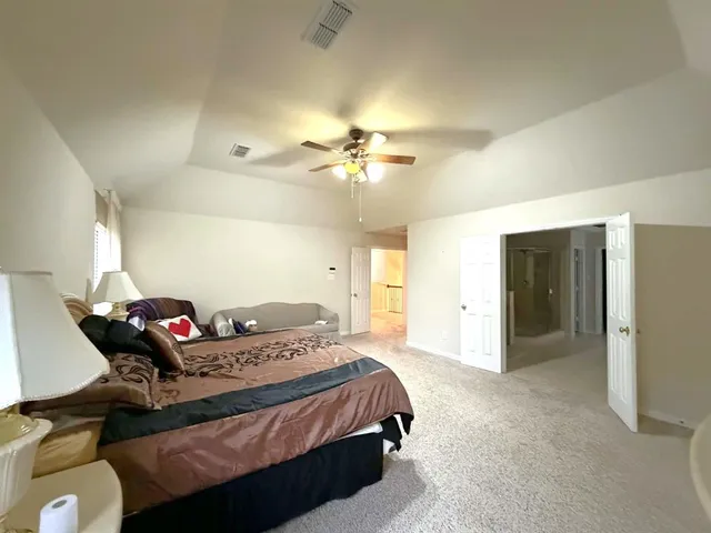 a spacious bedroom with a bed a couch and dresser