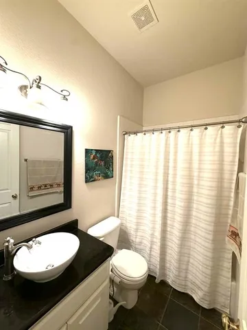 a bathroom with a toilet a sink and a mirror