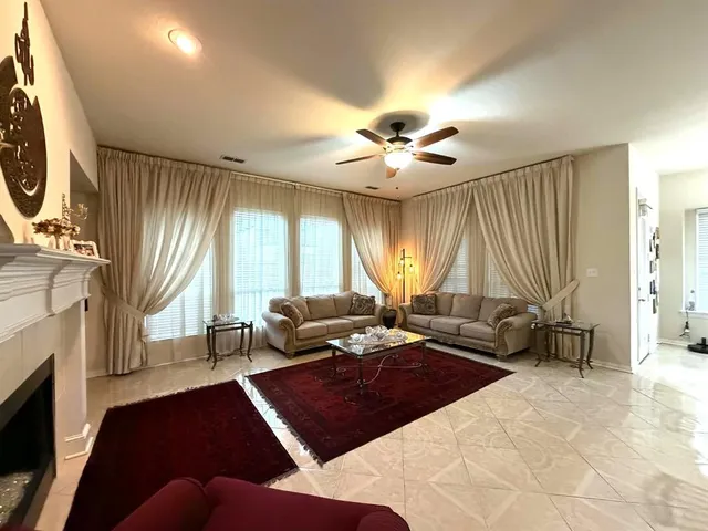 a living room with furniture a fireplace and large windows