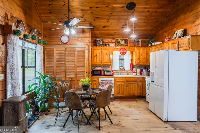 a kitchen with stainless steel appliances kitchen island granite countertop a table chairs in it and wooden floors