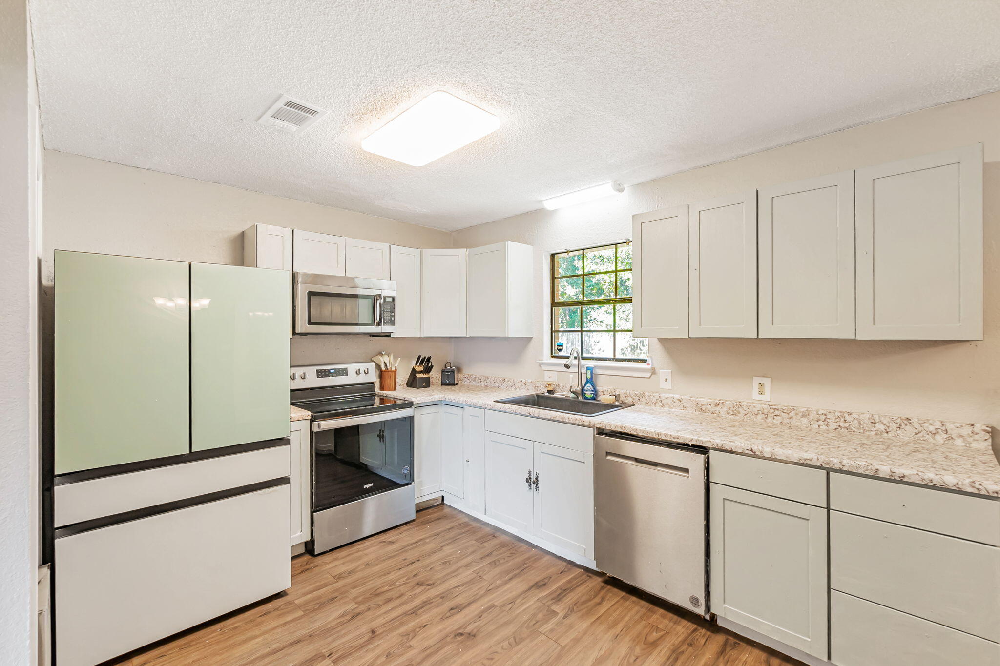 6517 Kennington Circle Milton, FL 32570 - Photo 12 of 37 a kitchen with granite countertop white cabinets and white appliances