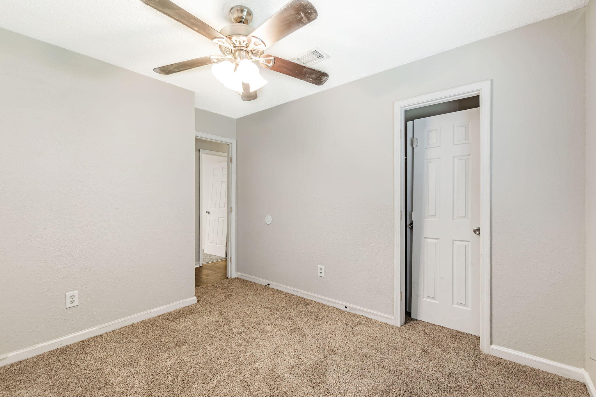6517 Kennington Circle Milton, FL 32570 - Photo 25 of 37 an empty room with a chandelier fan and windows
