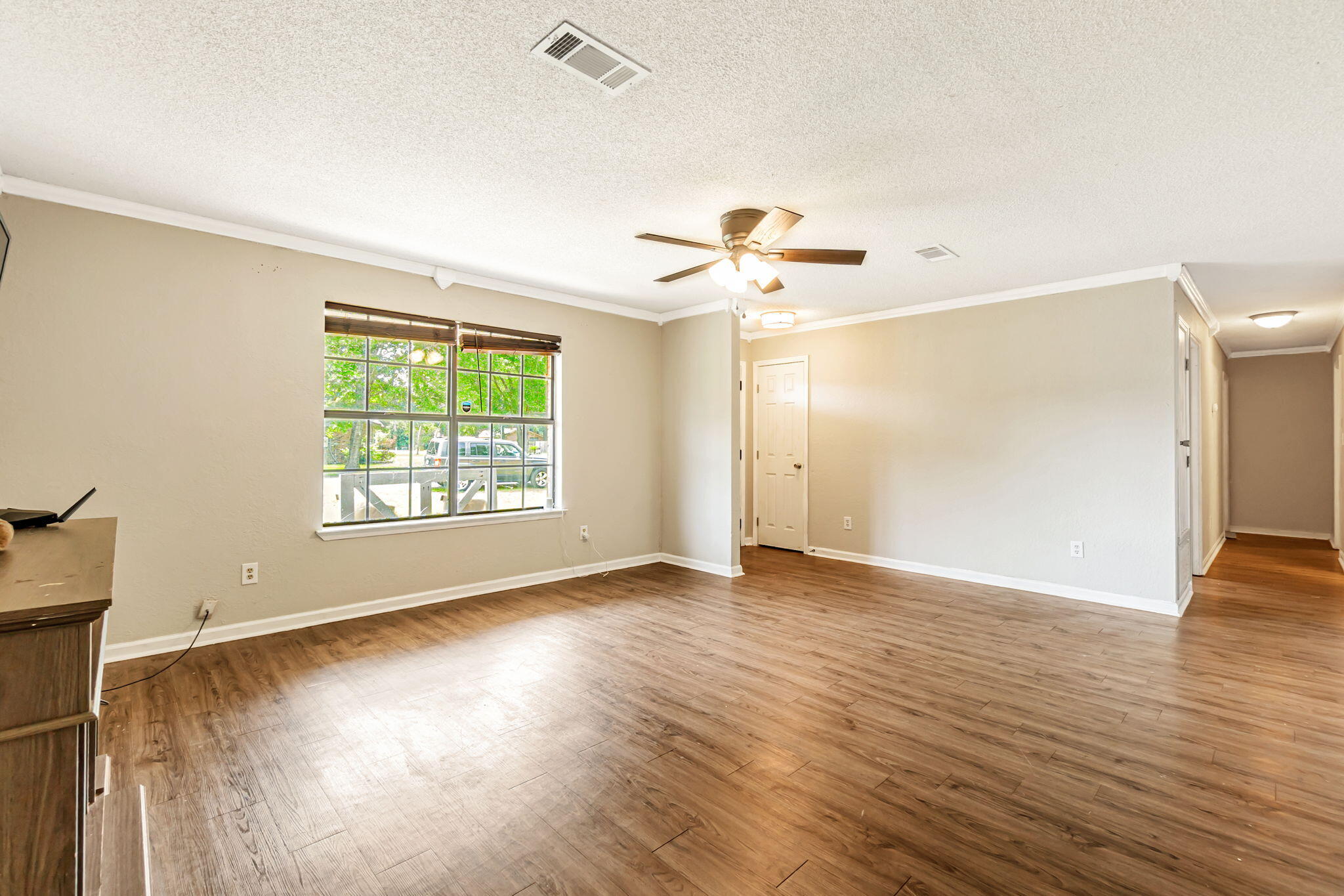 6517 Kennington Circle Milton, FL 32570 - Photo 9 of 37 an empty room with wooden floor chandelier and windows