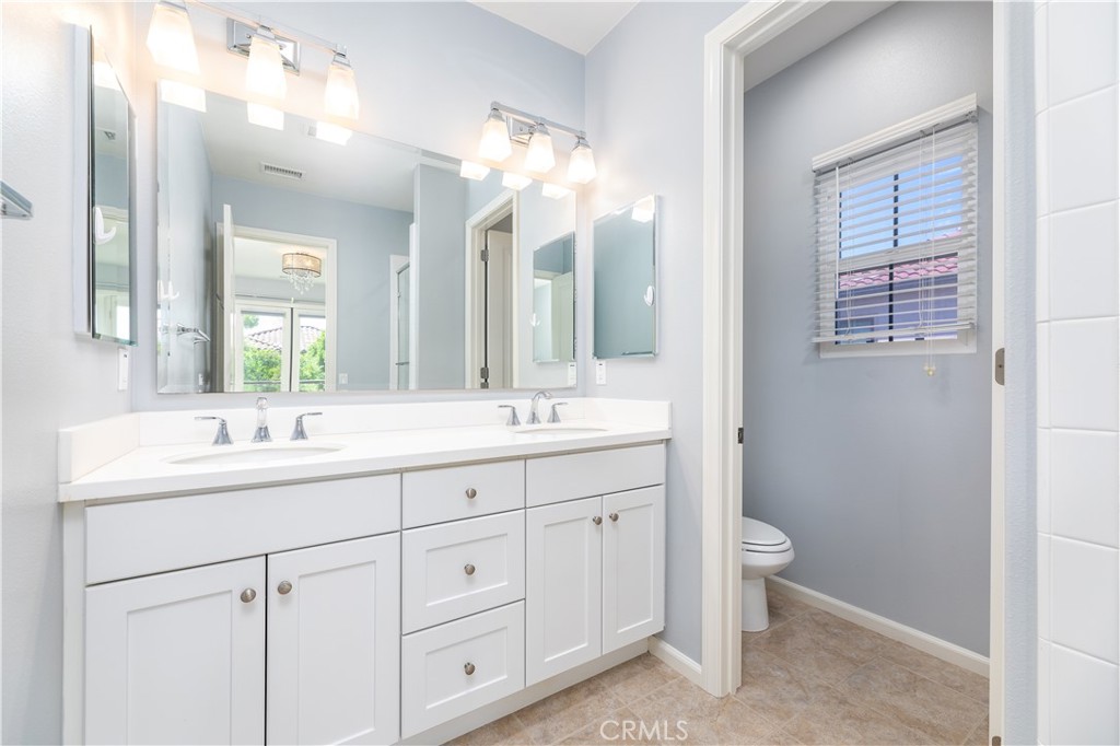 242 Firefly Irvine, CA 92618 - Photo 22 of 24 a bathroom with a double vanity sink a toilet and a mirror