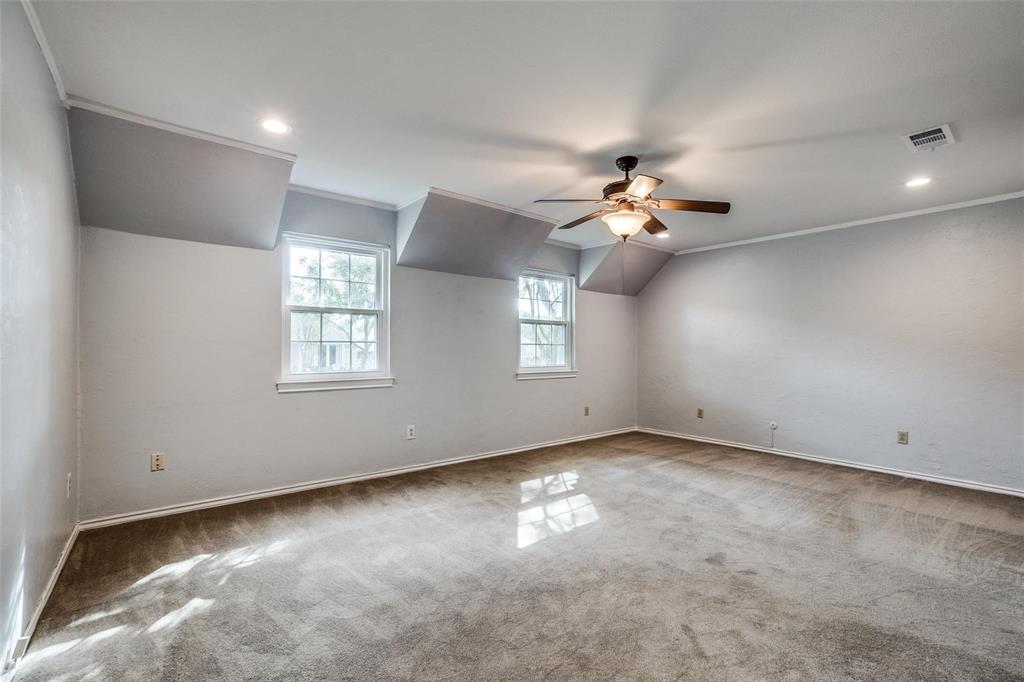 9911 Silver Creek Road Dallas, TX 75243 - Photo 13 of 28 Expansive room featuring two windows, recessed lighting, crown molding, and a ceiling fan with integrated lighting