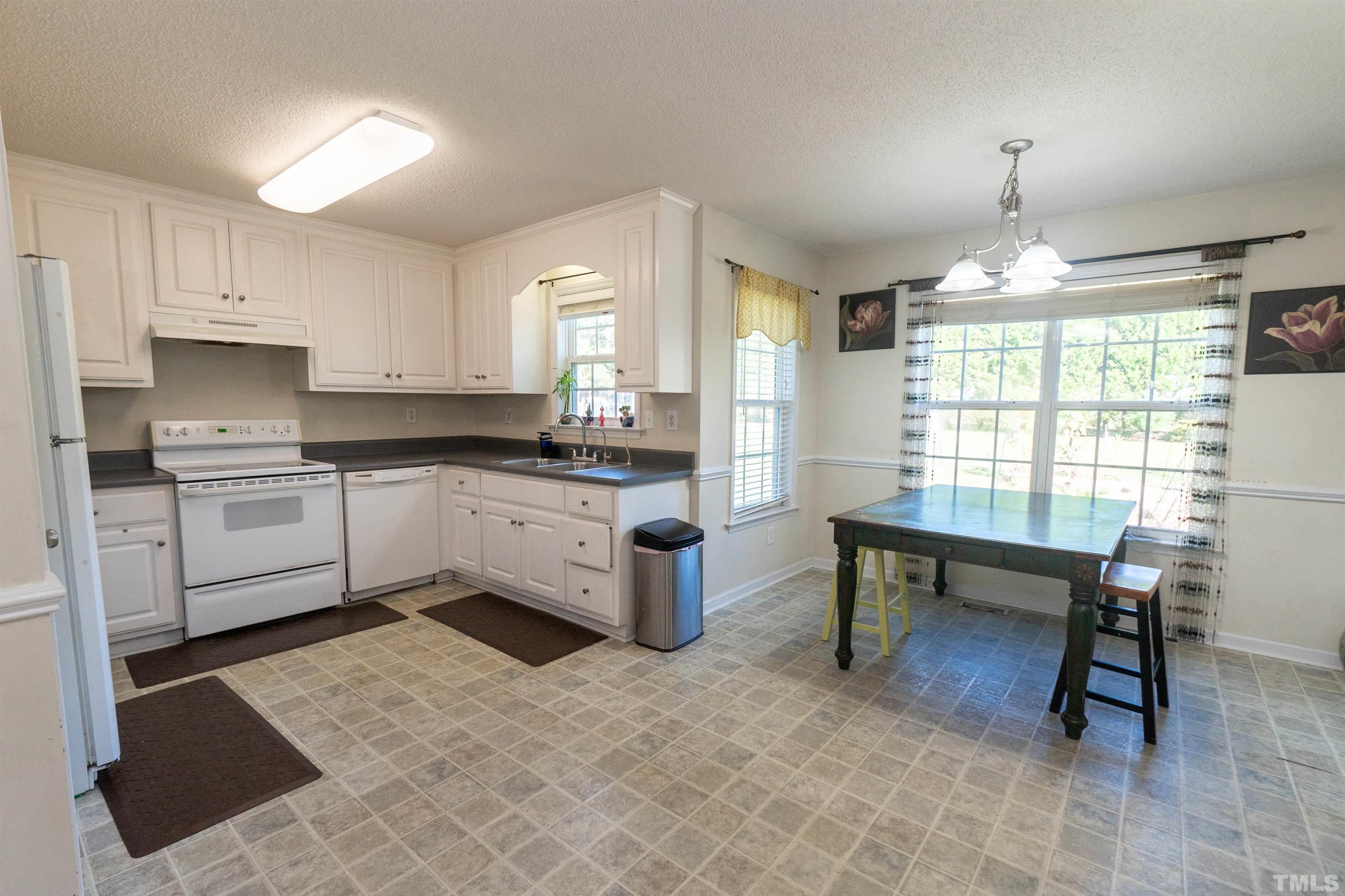 128 Edmondson Drive Willow Spring, NC 27592 - Photo 11 of 24 a kitchen with a white cabinets and white appliances